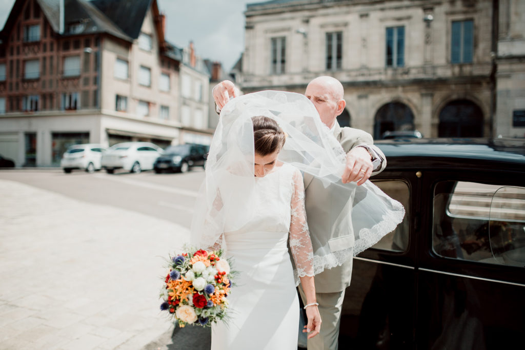 Le père de la mariée lui met son voile