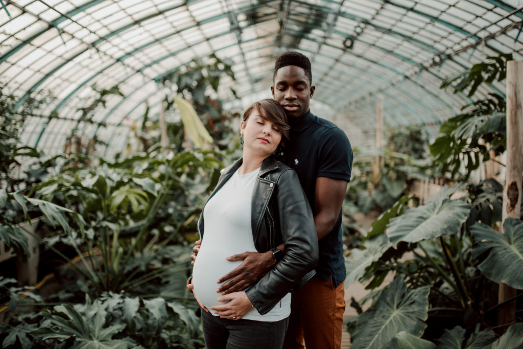 Couple aux Serres D'Auteuil à Paris lors d'une séance photo grossesse.