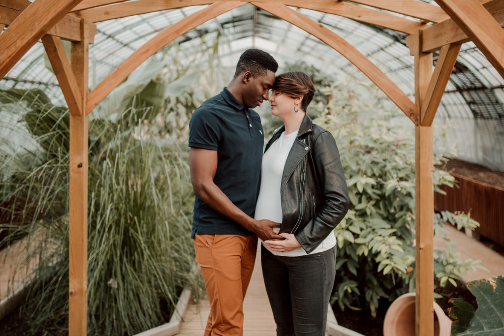 Couple aux Serres D'Auteuil à Paris lors d'une séance photo grossesse.