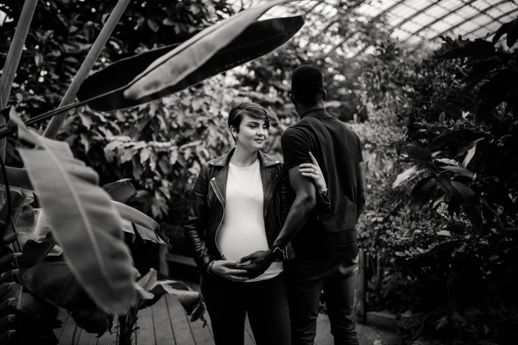 Couple aux Serres D'Auteuil à Paris lors d'une séance photo grossesse.