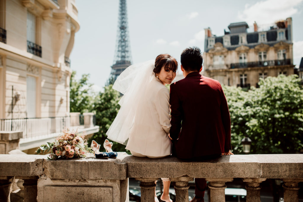 Couple regardant la Tour Eiffel lors d'une séance d'engagement à Paris.