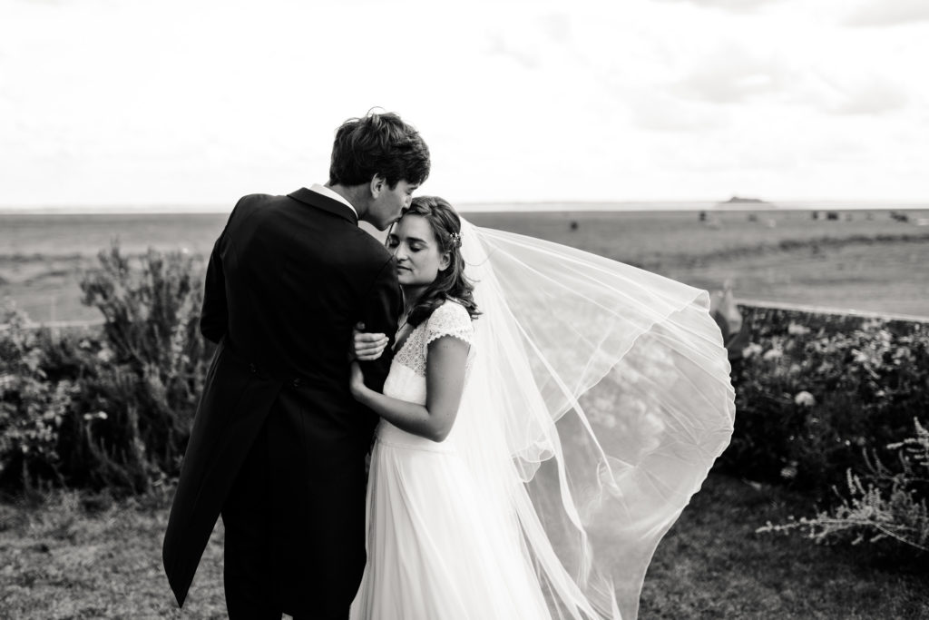 Couple s'embrassant dans la baie lors d'un mariage au Mont Saint Michel