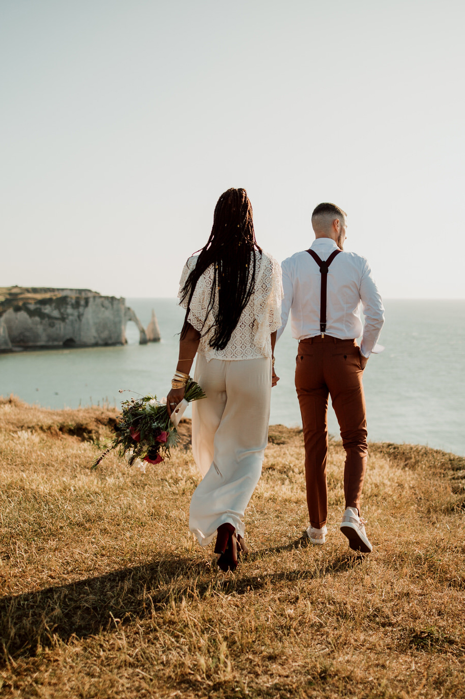 Jeune couple de mariés marchant sur les falaises d'Etretat