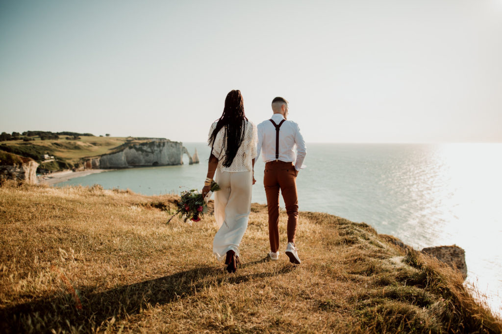 Couple marchant au coucher du soleil à Etretat