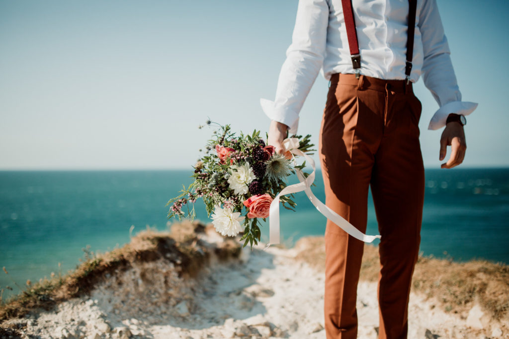 Bouquet de fleur de mariage tenu par le marié à Etretat