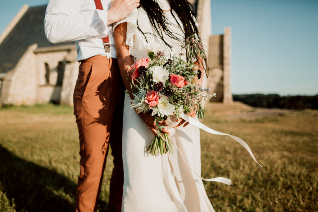 Couple sur les falaises d'etretat avec un bouquet de fleurs