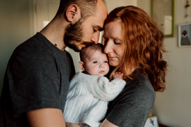 Jeunes parents avec leur bébé lors d'une séance famille à Paris.