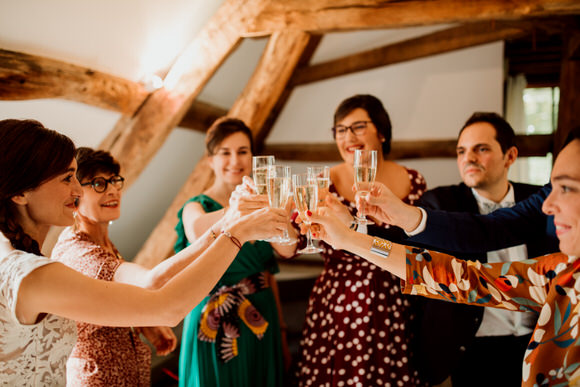 Témoins et mariée trinquent au champagne durant les préparatifs au domaine de serans